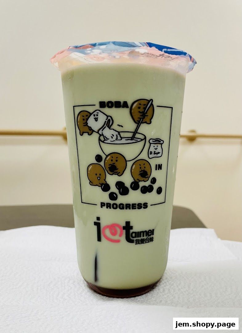 A cup of green bubble tea with cute cartoon characters and the shop's logo.