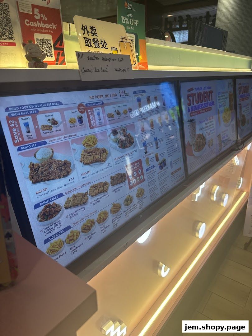 A digital menu board displaying fried chicken, bubble tea, and set meals with prices.