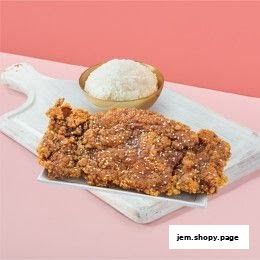 A crispy fried chicken cutlet served with a bowl of white rice on a white board.