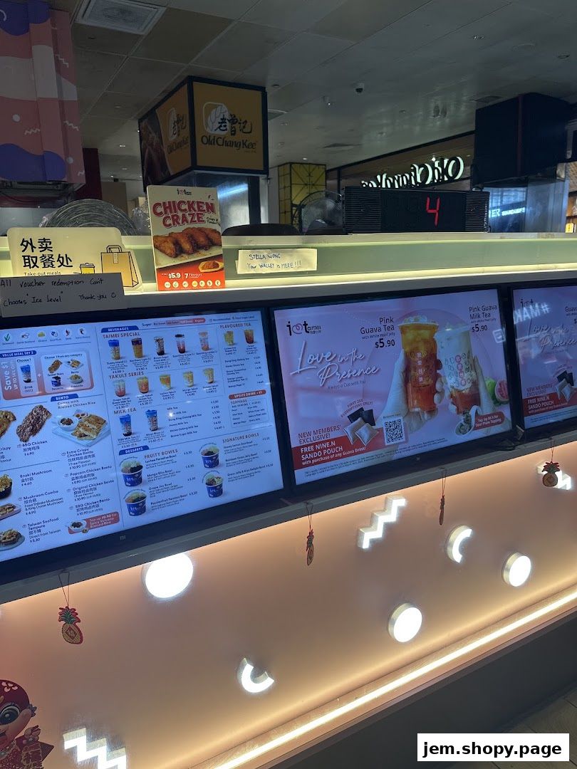 Digital menus display fried chicken, bubble tea, and fruit bowls with prices.