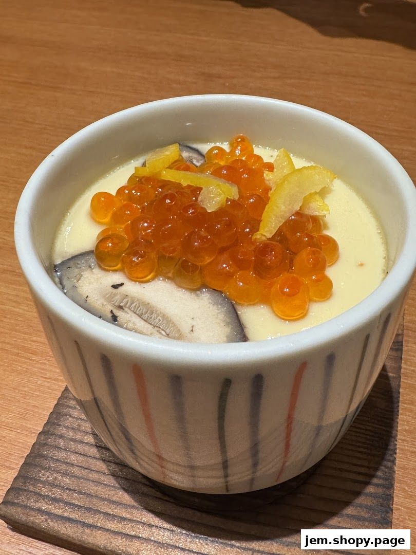 A close-up of a Japanese chawanmushi dish with ikura and shiitake mushrooms.