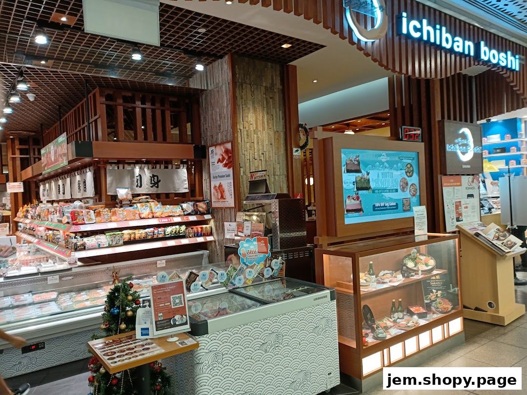The exterior of Ichiban Boshi JEM, a Japanese restaurant and market, with food displays and signage.
