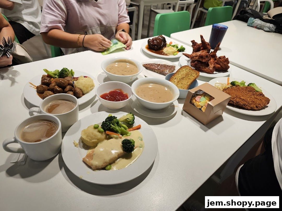 A table laden with various IKEA restaurant dishes, including meatballs, chicken wings, and salmon.