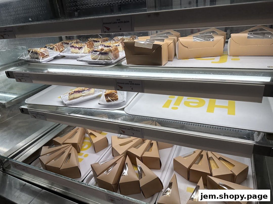 A display case filled with various cakes and pastries, some individually packaged.