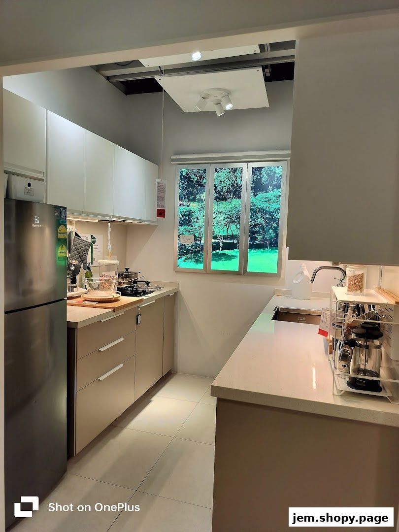A modern kitchen display with appliances, cabinets, and a window view.