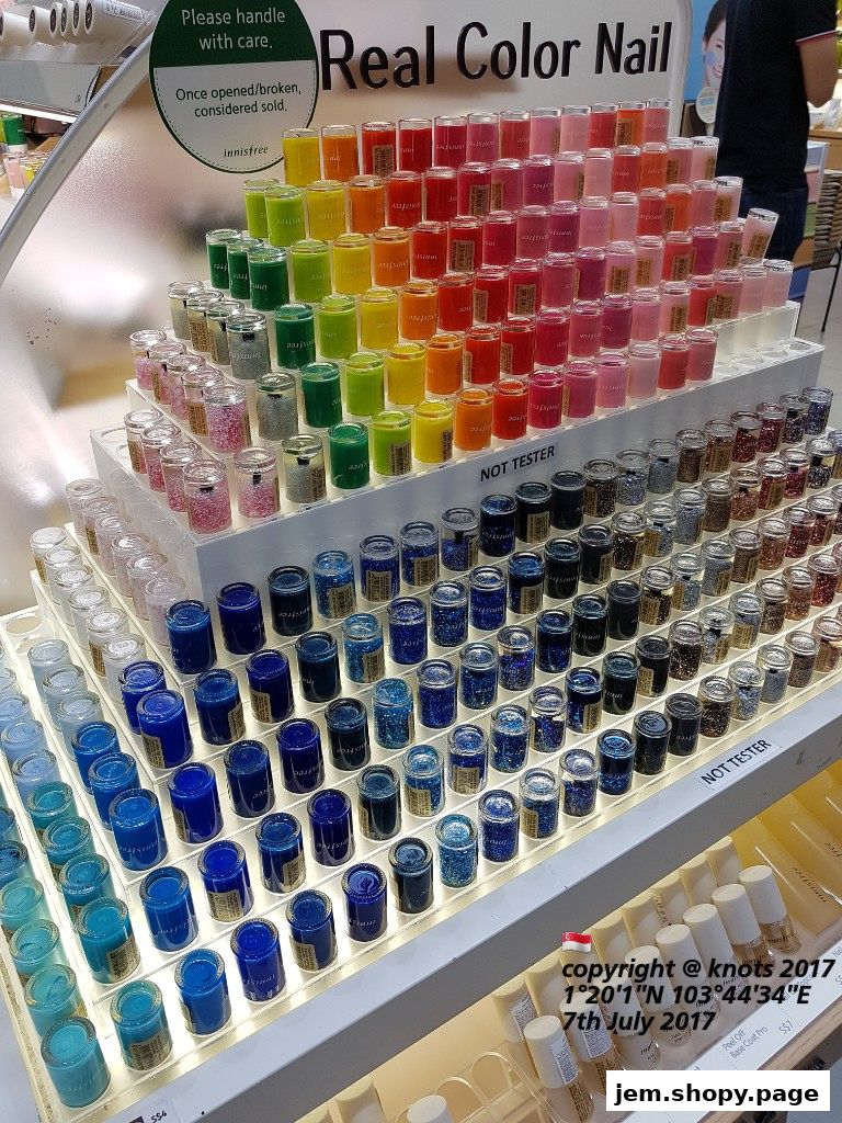 Display of colorful nail polish bottles arranged in rows and gradients.