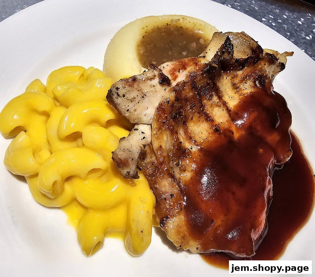 A plate of grilled chicken with mashed potatoes, gravy, and macaroni and cheese.