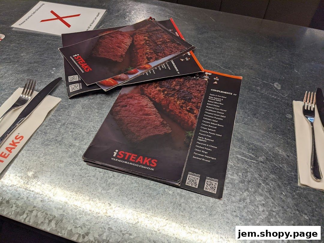A stack of menus from iSTEAKS restaurant showing steak dishes and side complements.