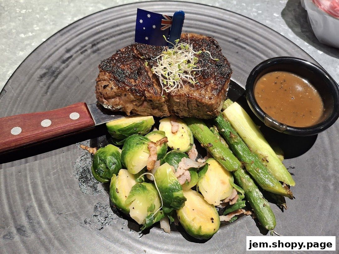 A perfectly grilled steak served with Brussels sprouts, asparagus, and a side of sauce.