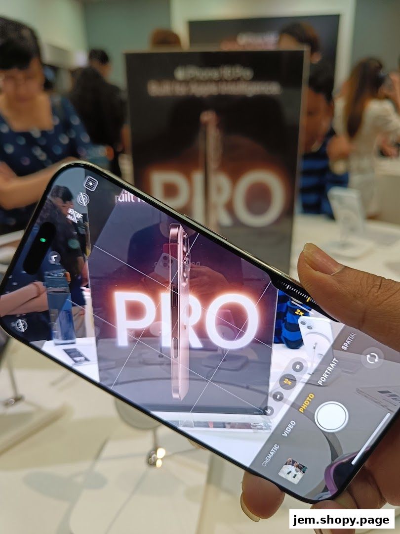 A hand holds a smartphone displaying an iPhone Pro advertisement in a retail store.