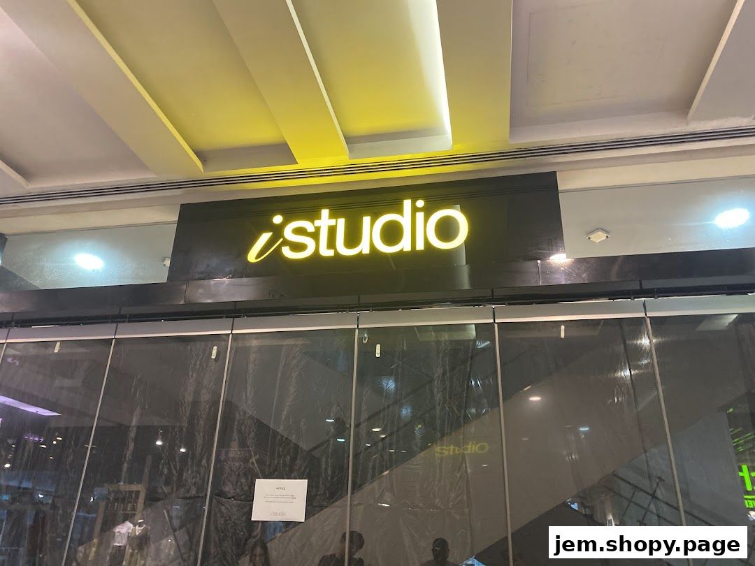 The illuminated 'iStudio' logo above a shop entrance with reflective glass doors.