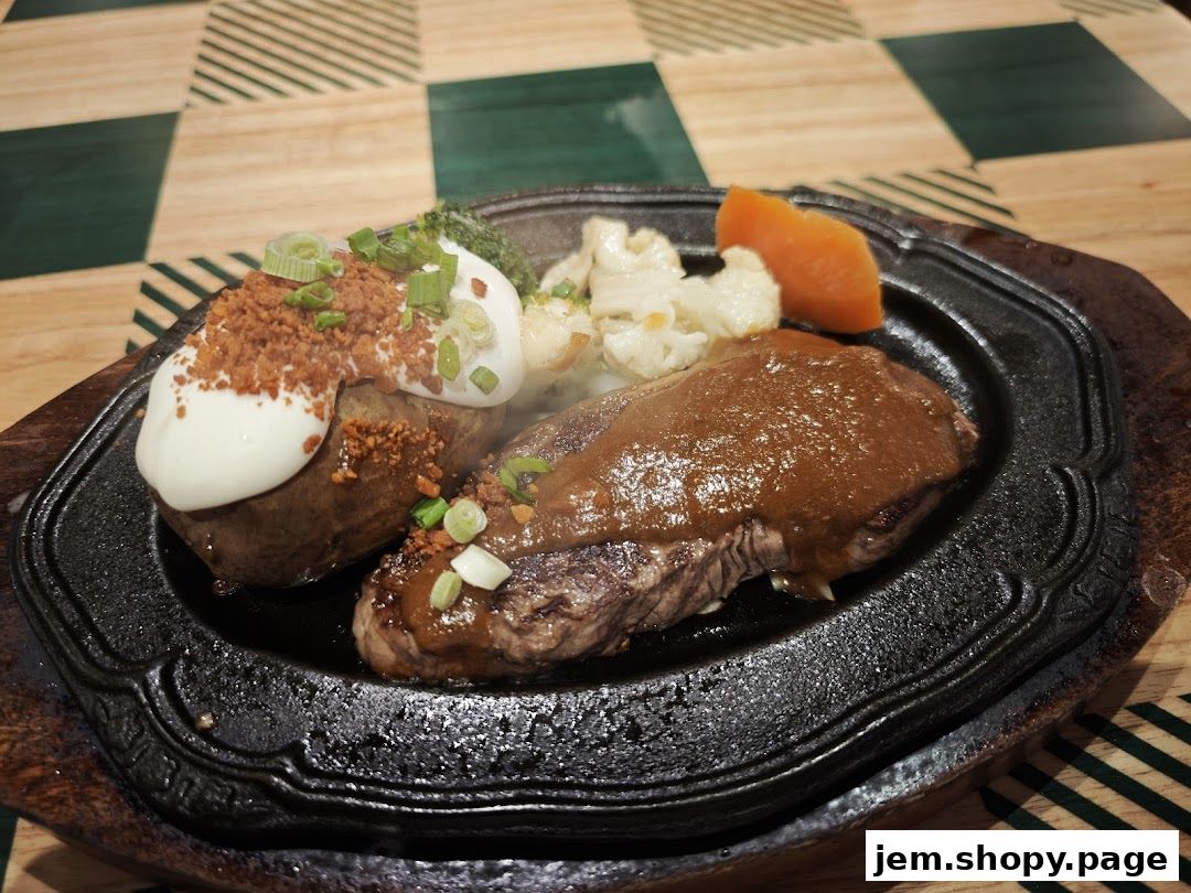 A sizzling steak served with a baked potato, vegetables, and sauce on a cast iron plate.