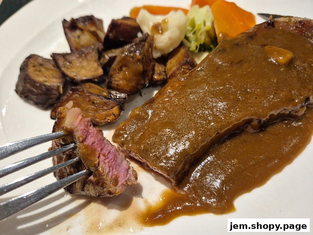 A fork is lifting a piece of juicy steak with brown sauce and roasted potatoes.