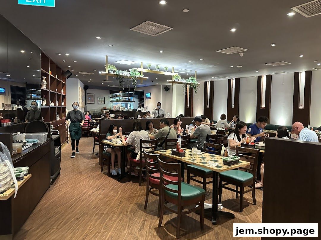 Diners enjoying meals inside a busy restaurant with staff serving.