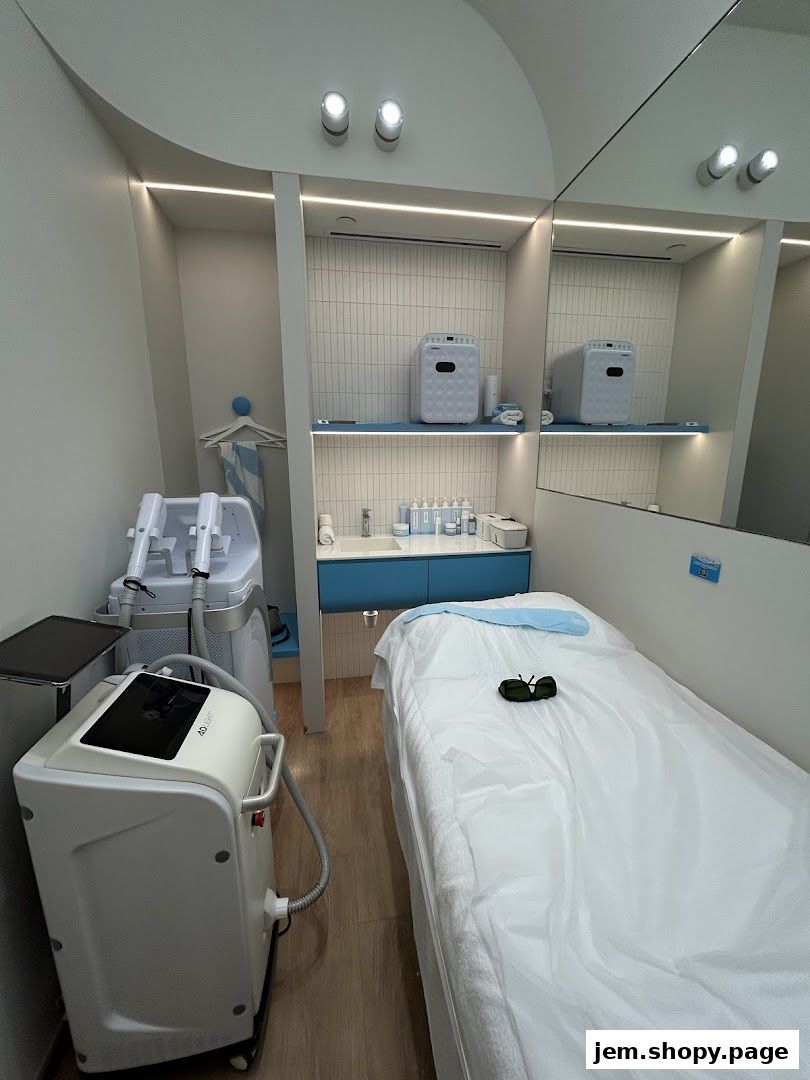 Interior of a clean, modern beauty treatment room with a bed and IPL machines.