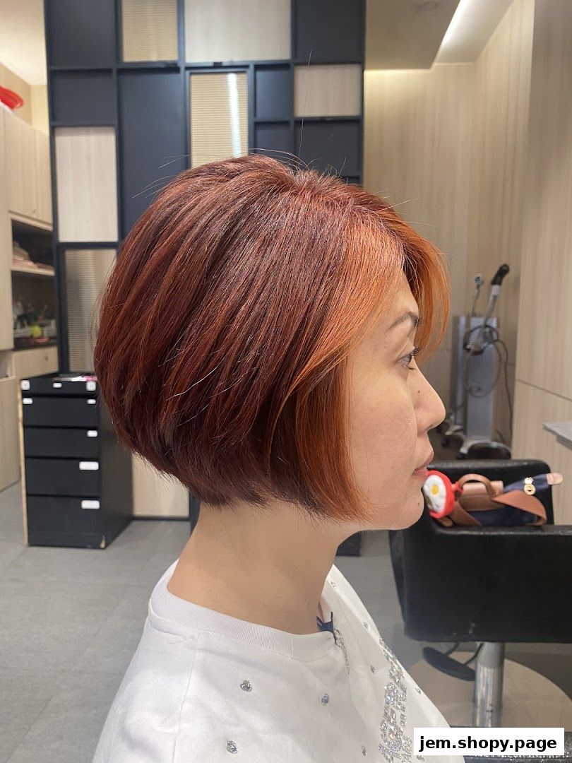 A woman with a stylish auburn bob haircut in a salon setting.