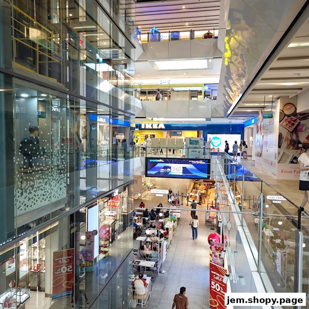 Interior view of a multi-level shopping mall with various shops and a food court.