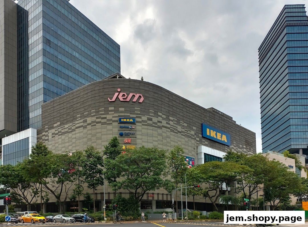 The Jem shopping mall exterior with various store logos and surrounding trees.