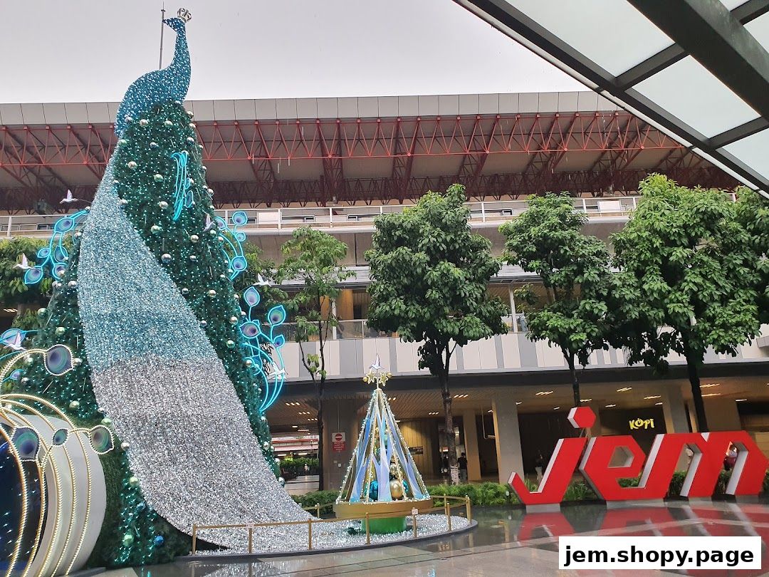 A large, festive peacock-themed Christmas tree stands outside the Jem shopping mall.