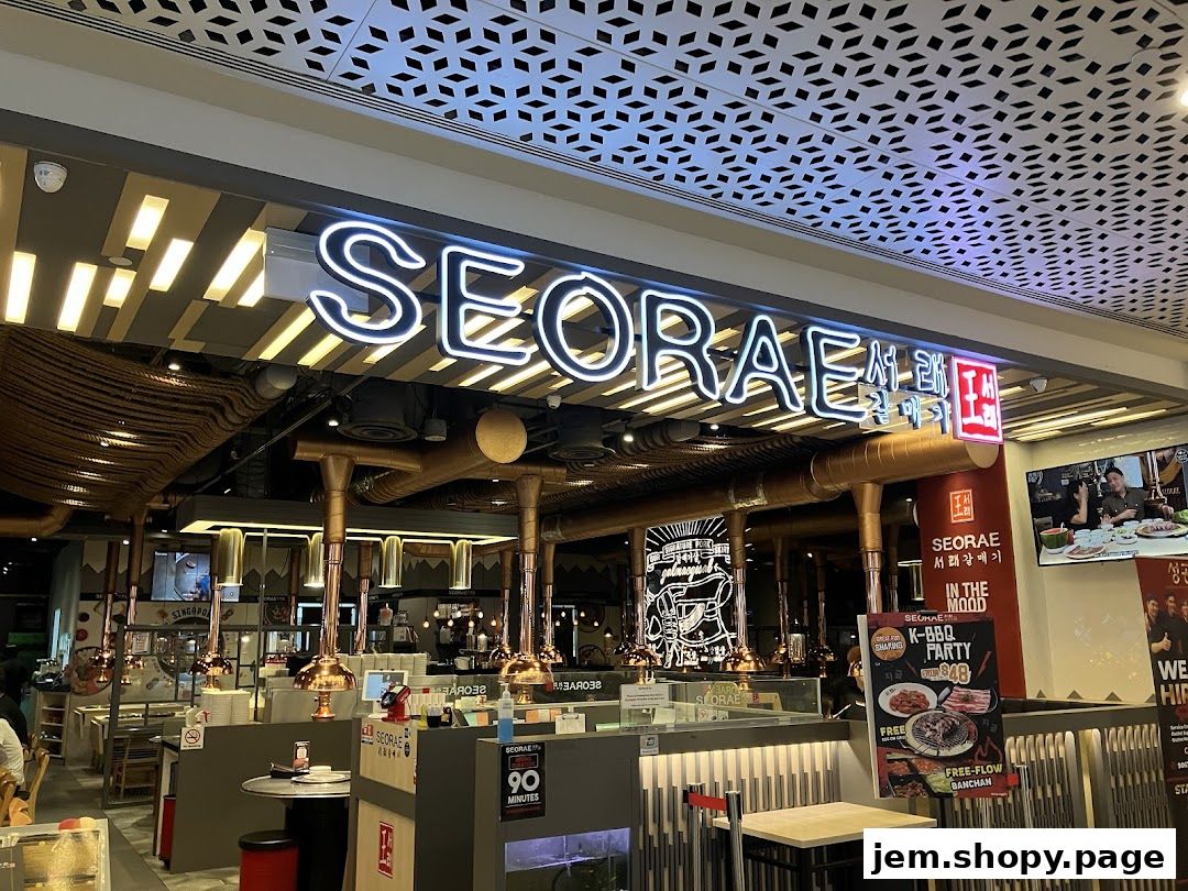The exterior of a Korean BBQ restaurant called Seorae, featuring neon signs and dining tables.