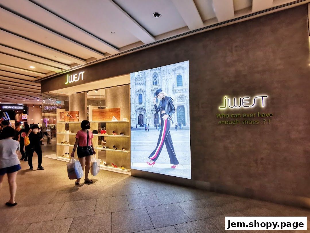 A shoe store called jwest with a large digital display and shoes displayed on shelves.