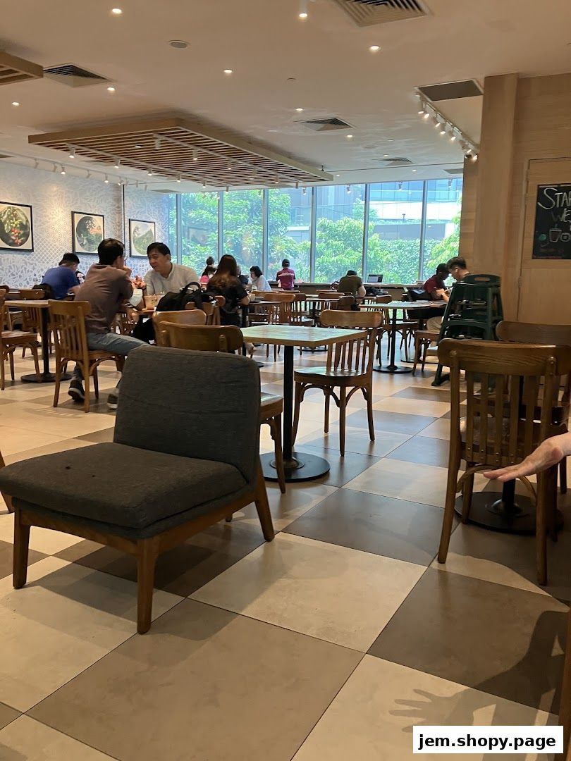 Interior of a busy cafe with people dining and working at tables.