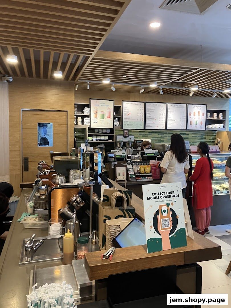Interior view of a Starbucks coffee shop with a counter, menu boards, and customers.