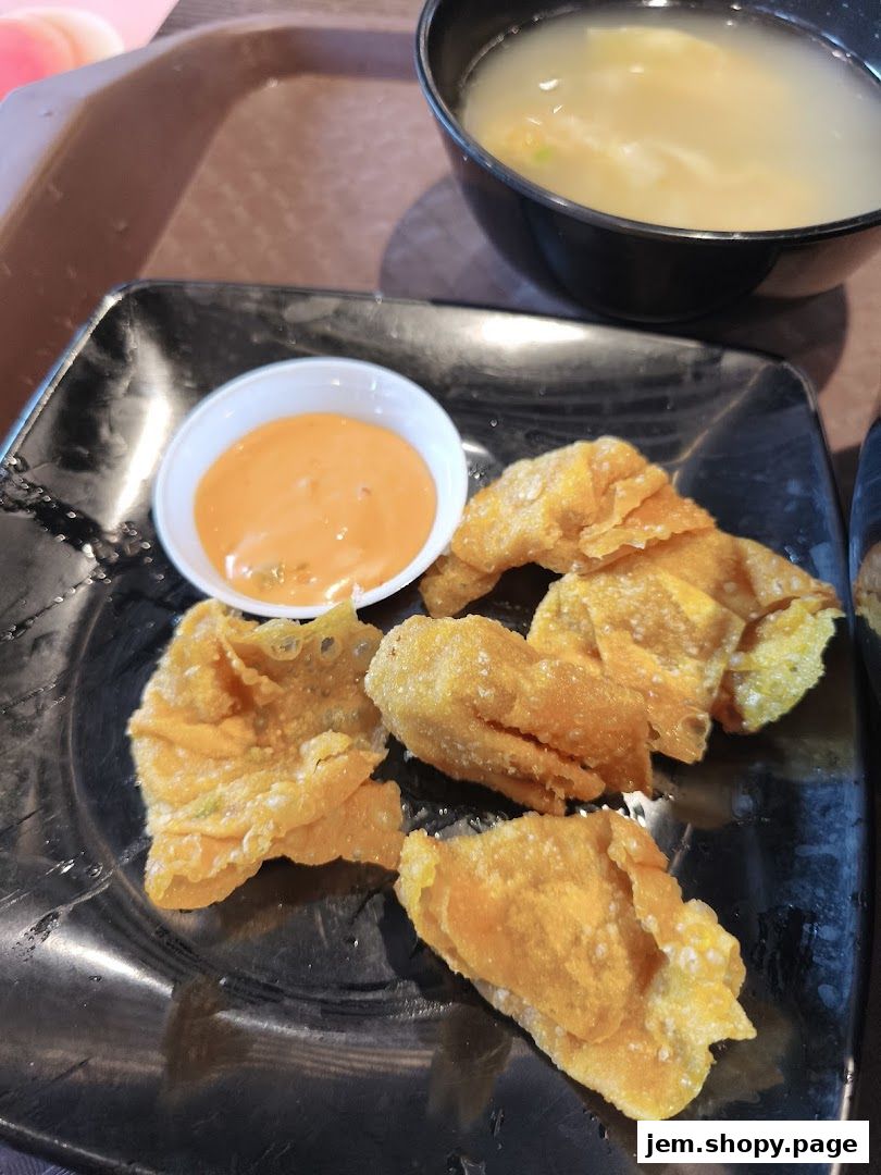 Crispy fried wantons served with a dipping sauce and a bowl of soup.