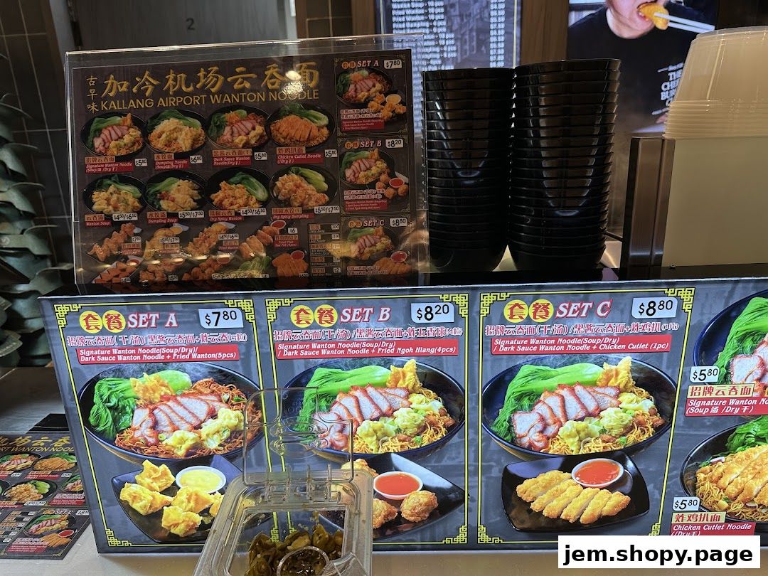 A menu board for Kallang Airport Wanton Noodle featuring various set meals and noodle dishes.