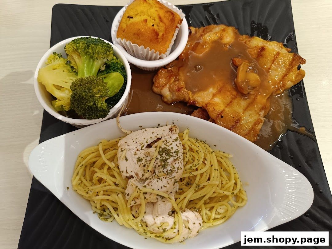 A delicious meal featuring grilled chicken, spaghetti, broccoli, and a muffin.
