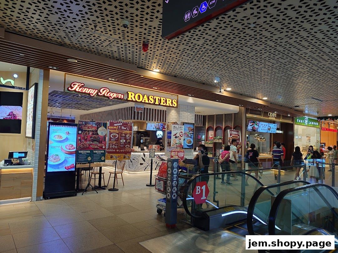 The entrance of Kenny Rogers Roasters Singapore with promotional posters and digital displays.