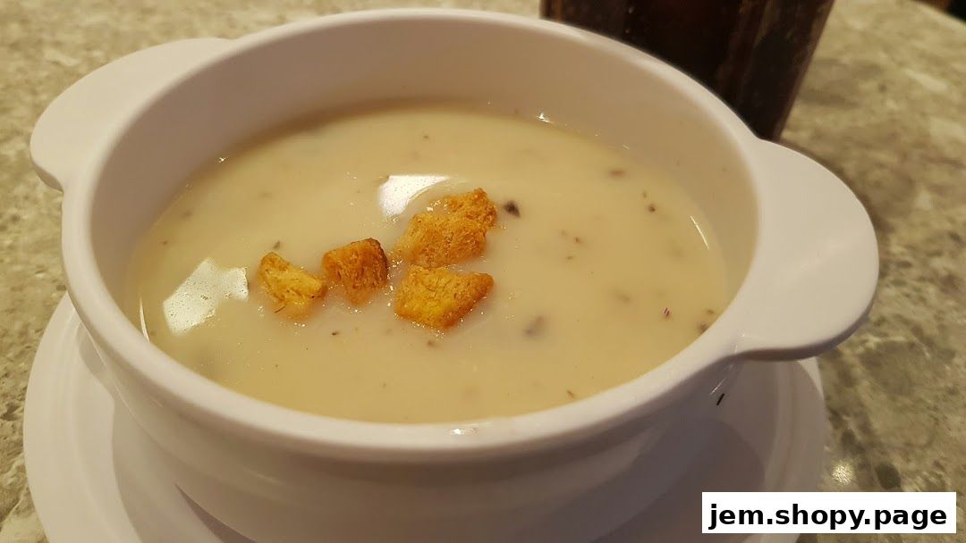 A close-up shot of a creamy mushroom soup with croutons in a white bowl.