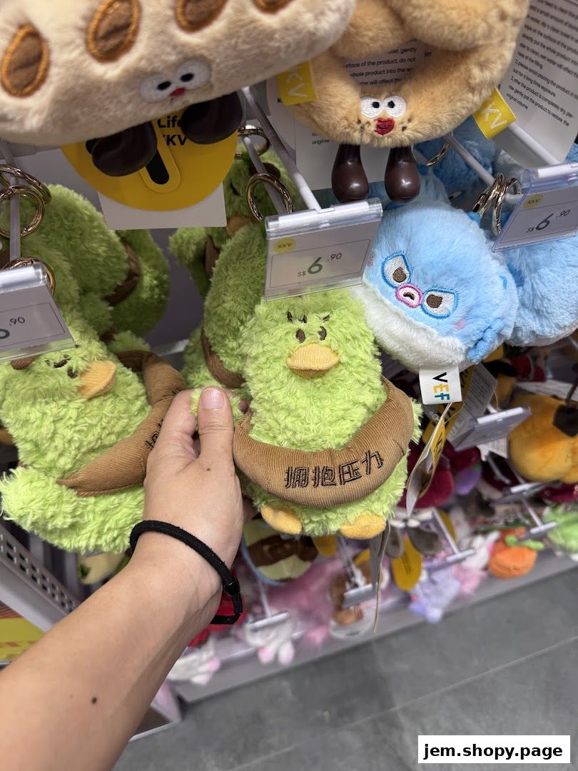 A hand reaches for cute, plush keychains shaped like avocados and other characters.