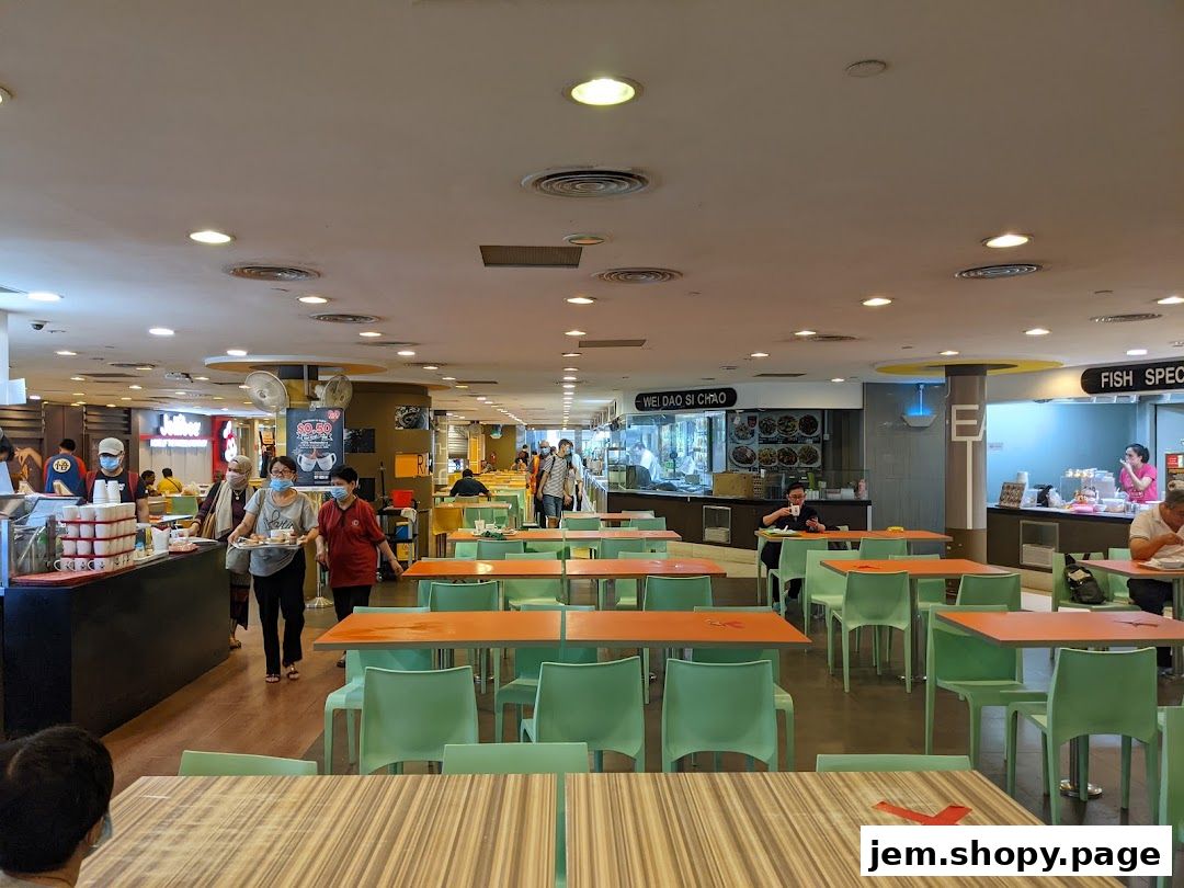 Interior view of a busy Kopitiam Food Hall with dining tables and food stalls.