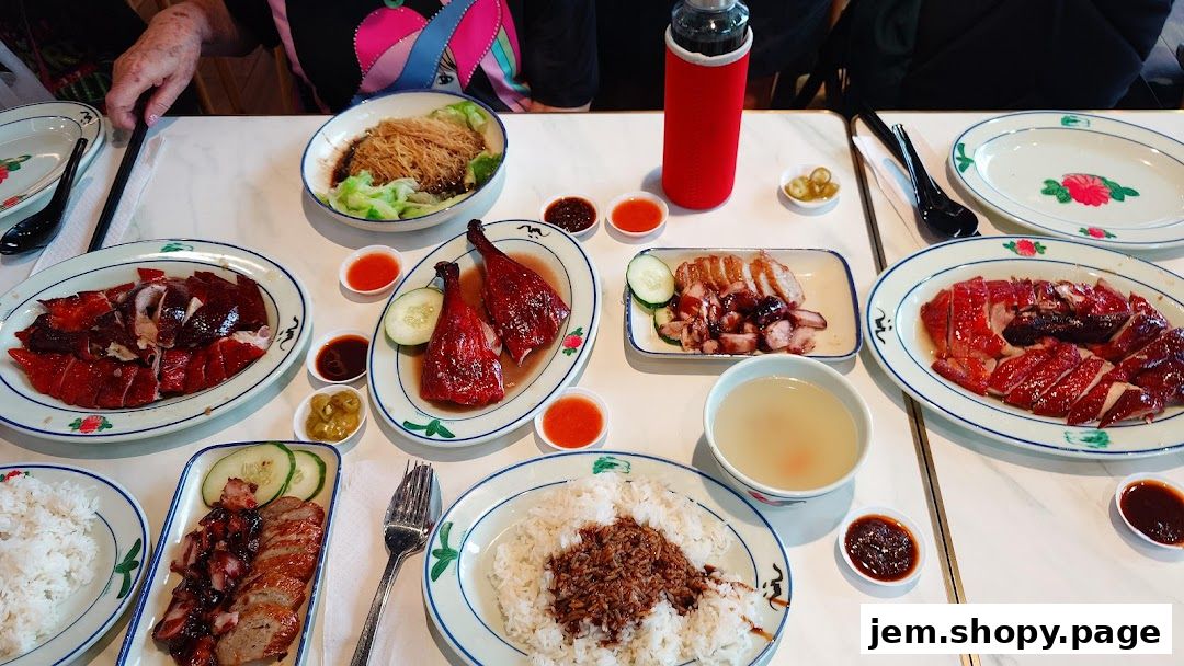 A table laden with various Chinese roasted meats, rice, and soup, ready for a meal.