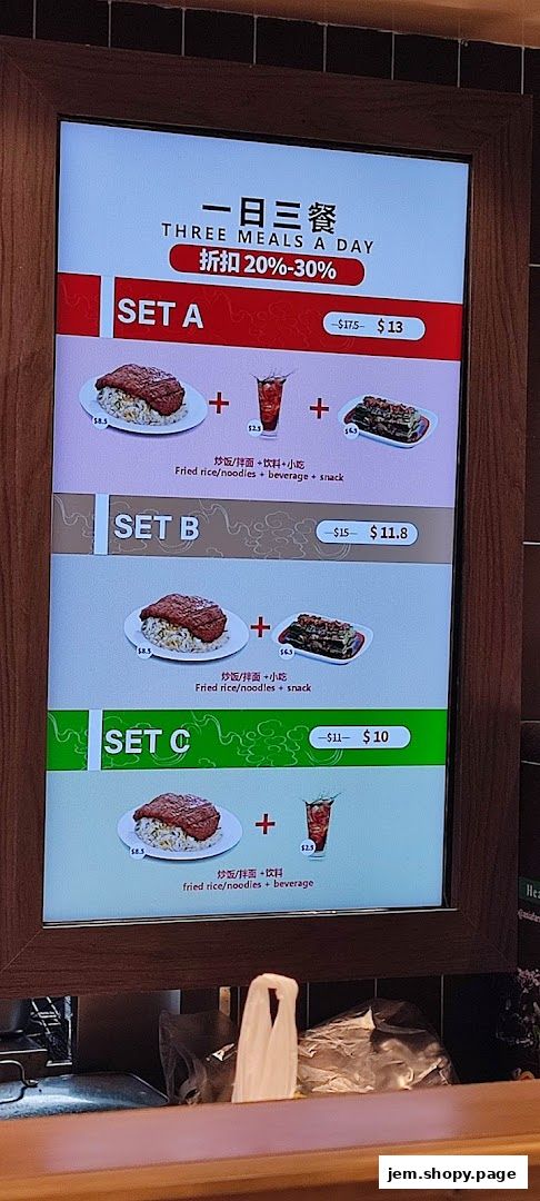 A digital menu board displays three meal sets with prices and images of food and drinks.