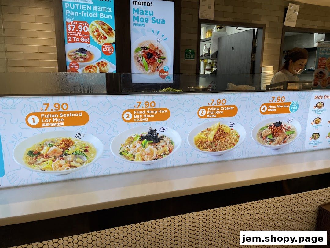 A food stall display showcasing various noodle and rice dishes with prices.