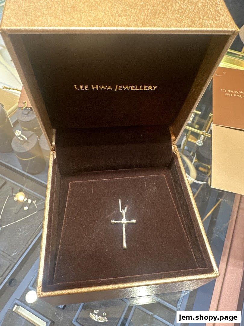 A cross pendant displayed in an open jewelry box from Lee Hwa Jewellery.