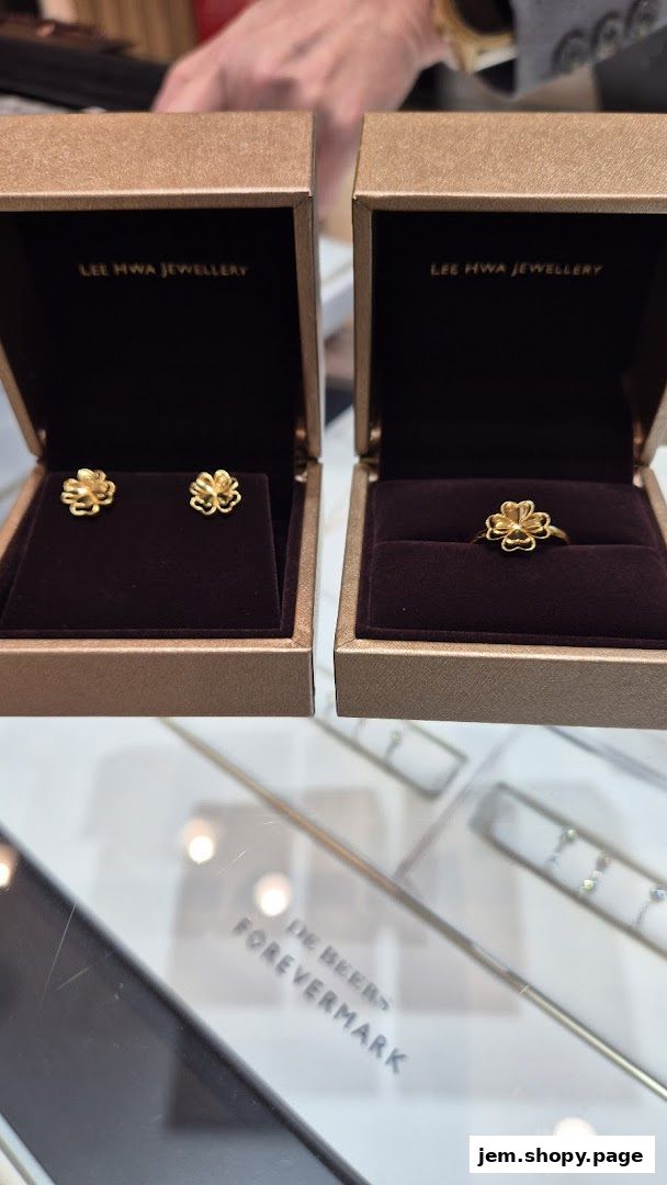 Elegant gold floral earrings and ring displayed in branded boxes from Lee Hwa Jewellery.