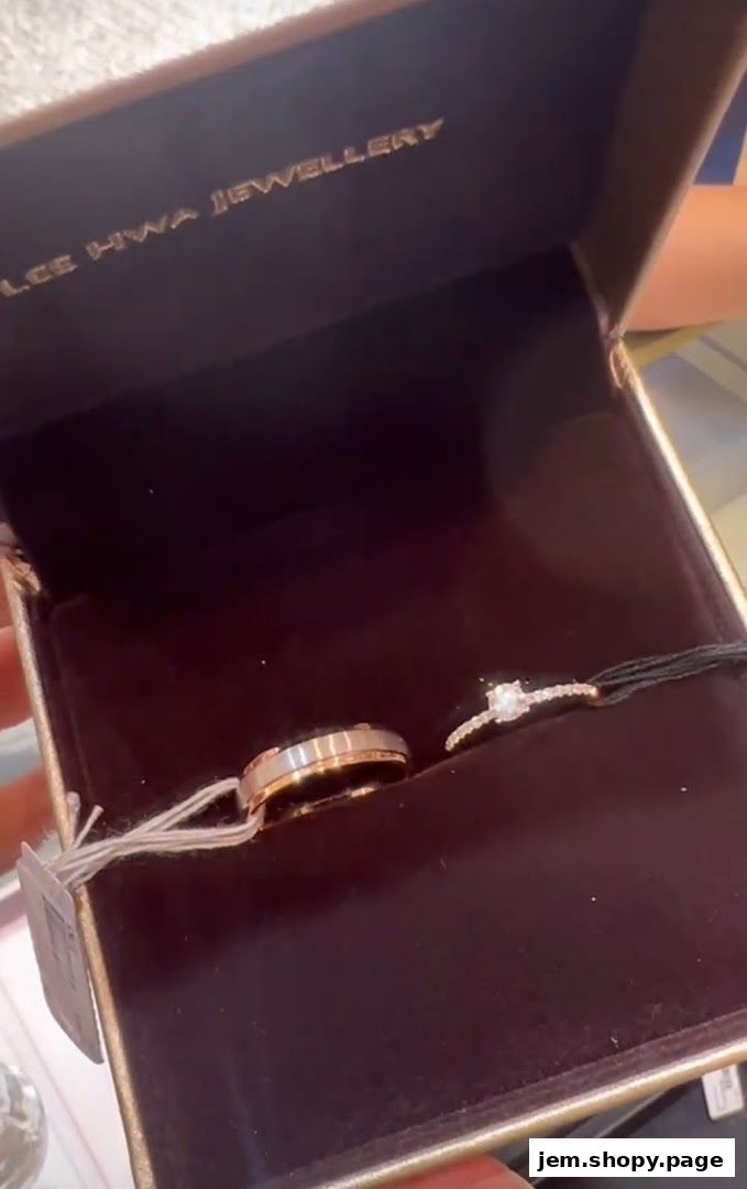A jewelry box displaying a wedding band and an engagement ring from Lee Hwa Jewellery.