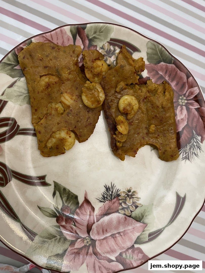 Two pieces of savory food with shrimp on a decorative plate.