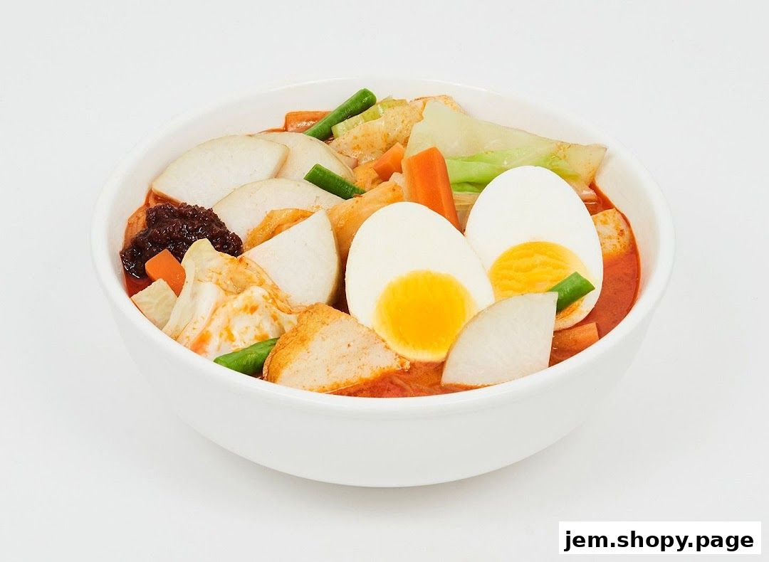 A bowl of delicious laksa with eggs, vegetables, and seafood.
