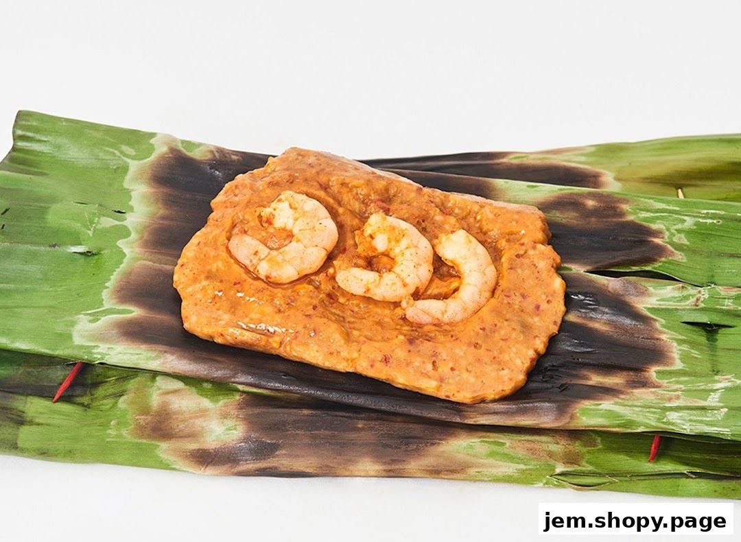 A close-up of grilled otah otah with prawns, served on banana leaves.