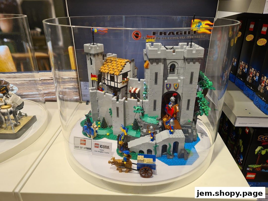 A detailed LEGO castle display inside a clear cylindrical case at a LEGO store.