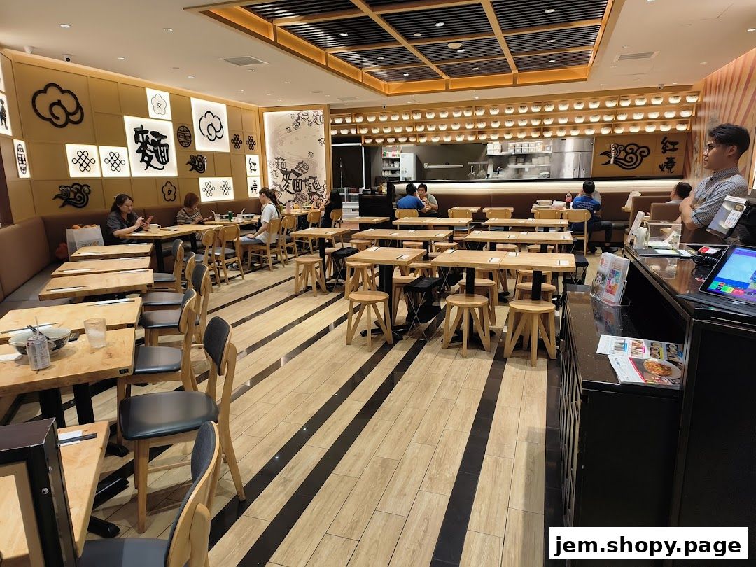 Interior of LeNu Chefs Wai Noodle Bar with tables, chairs, and decorative elements.