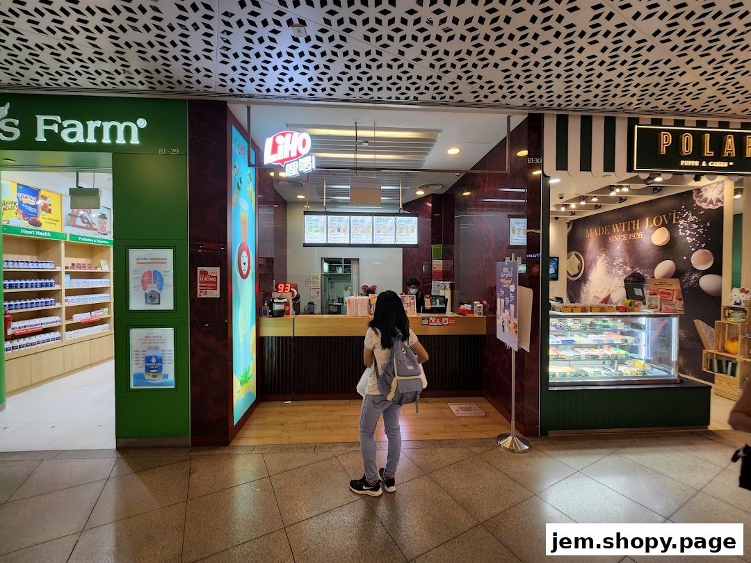 A view of the LiHO TEA shop entrance with a customer standing in front.