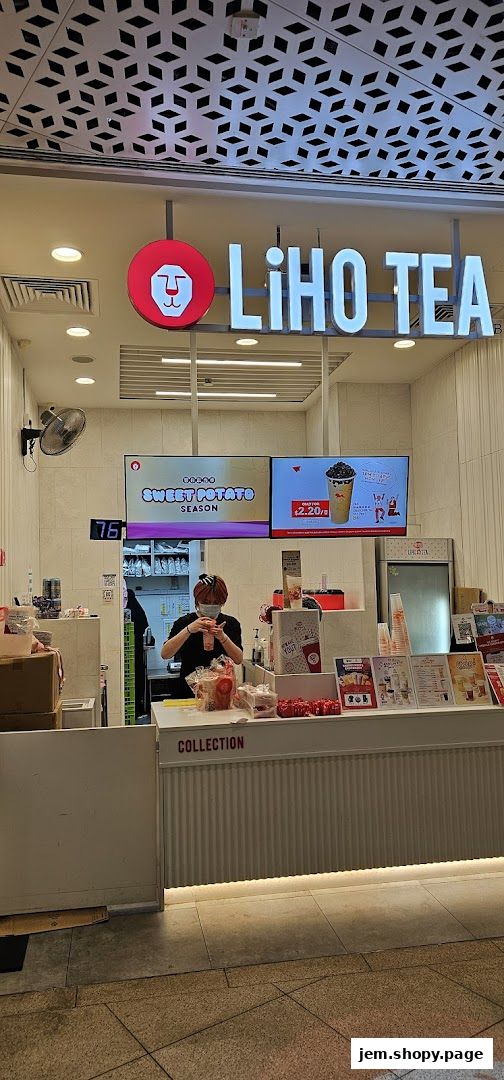 A LiHO TEA shop counter with a staff member preparing a drink and promotional displays.