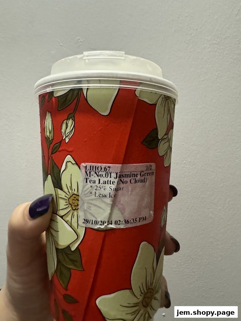 A hand holds a LiHO TEA cup with a floral design and order details.