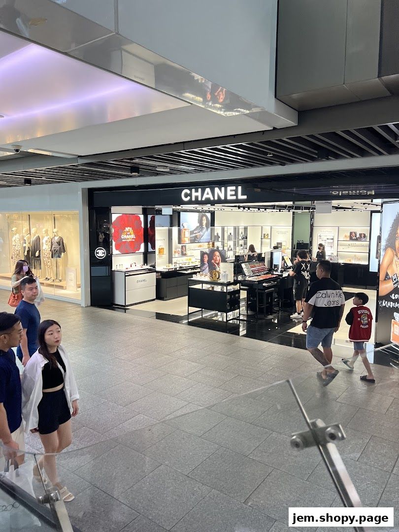 A Chanel store with various beauty products displayed and customers browsing.