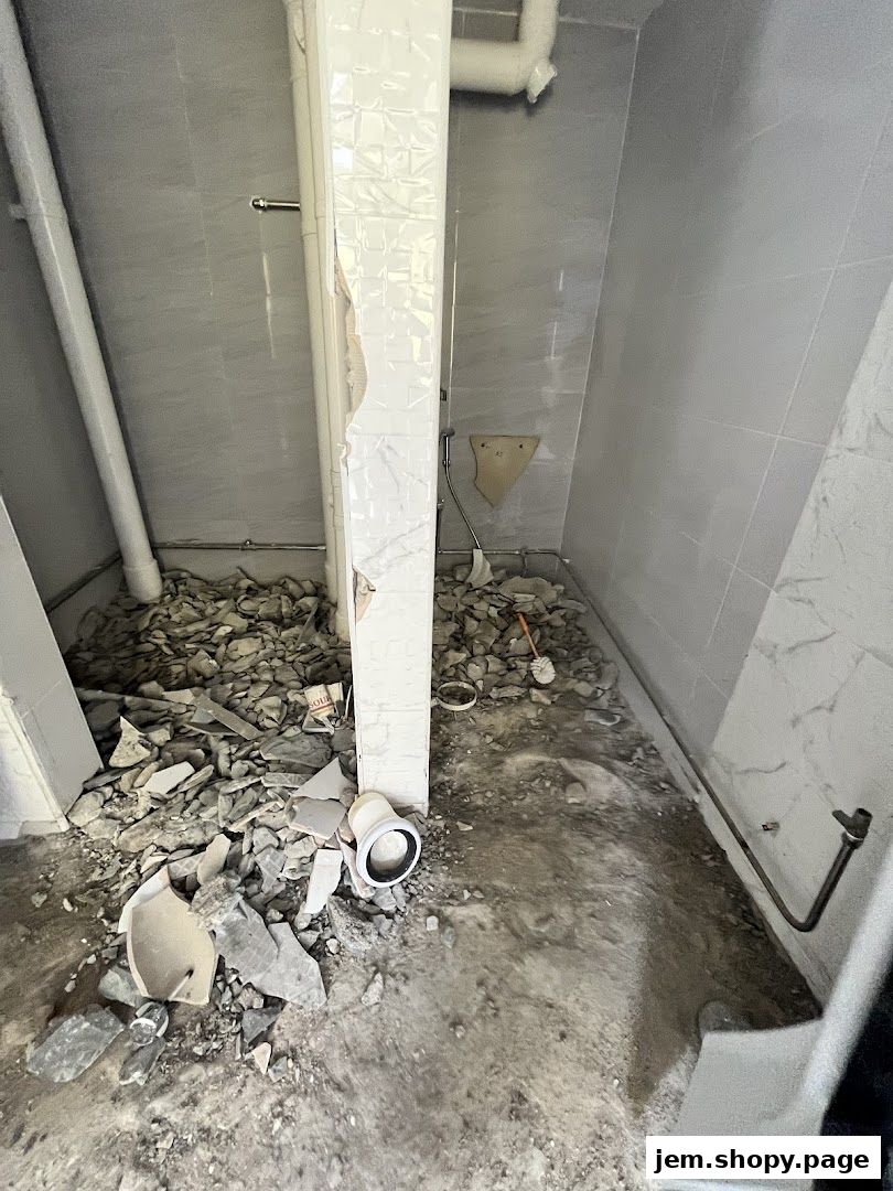 Interior of a room under renovation with debris and exposed pipes.